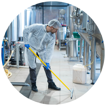 Man cleaning the floor in a food processing facility